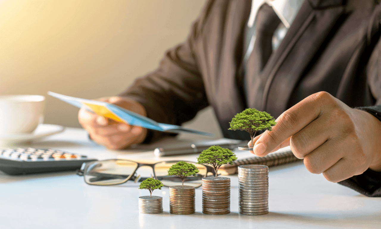 A business professional handling coins with miniature trees on top, symbolizing investment growth and financial sustainability.